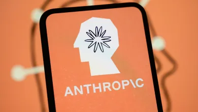 The Anthropic logo is displayed on the screen of a smartphone with the company's branding in the background.