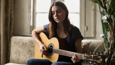 AI-generated image: A young woman is sitting on a couch and playing an acoustic guitar.
