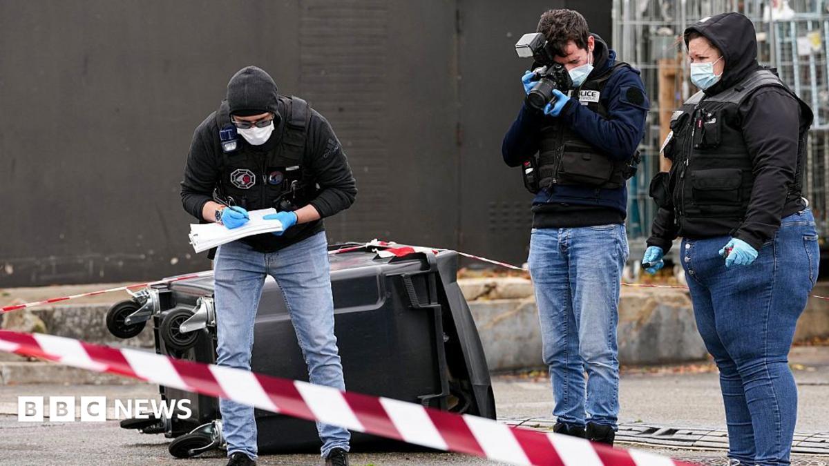 Police officers look at evidences on a site of a petrol station where a man opened fire from his car, killing one person and…