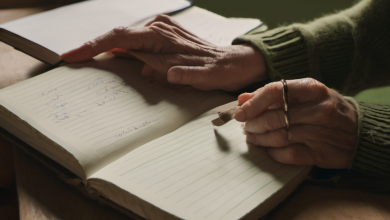 AI-generated image: The image shows a person's hands holding a pen over an open notebook.
