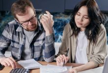 Couple reviewing household bills and finances at a kitchen table