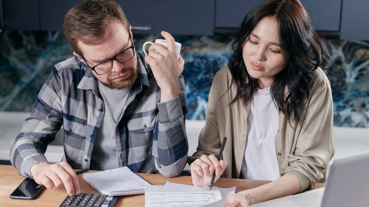 Couple reviewing household bills and finances at a kitchen table