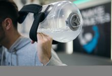 Fitness enthusiast uses unique water jug for exercise in modern gym during evening workout session.jpg
