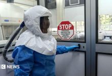 A laboratory technologist wearing protective equipment as she prepares to enter the Viral Hemorrhagic Fever Laboratory at Uganda Virus Research Institute in Entebbe, Uganda