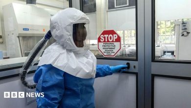 A laboratory technologist wearing protective equipment as she prepares to enter the Viral Hemorrhagic Fever Laboratory at Uganda Virus Research Institute in Entebbe, Uganda