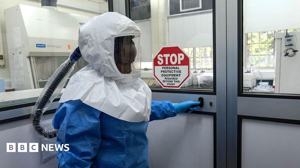 A laboratory technologist wearing protective equipment as she prepares to enter the Viral Hemorrhagic Fever Laboratory at Uganda Virus Research Institute in Entebbe, Uganda