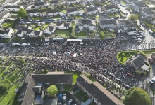 A drone shot of the rally gathered at the mouth of Drumcree Road into the north end of Garvaghy Road on 3 October.png