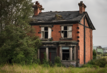 AI-generated image: A dilapidated, two-story brick house with a slate roof.