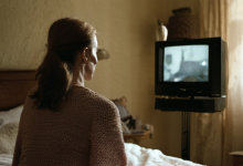 AI-generated image: A woman with brown hair pulled back into a ponytail is sitting on a bed.