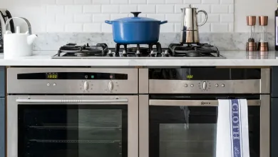 A double oven and gas cooker with a blue cast iron pot on top