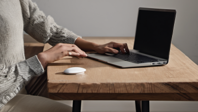 AI-generated image: A person's hands are visible, using a laptop and a mouse on a wooden table.