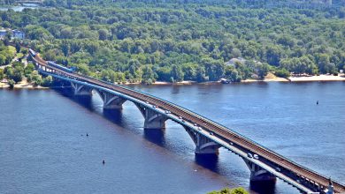 Smoke rising from a drone strike on the Pivnichnyi Bridge in Kyiv, with vehicles on the road