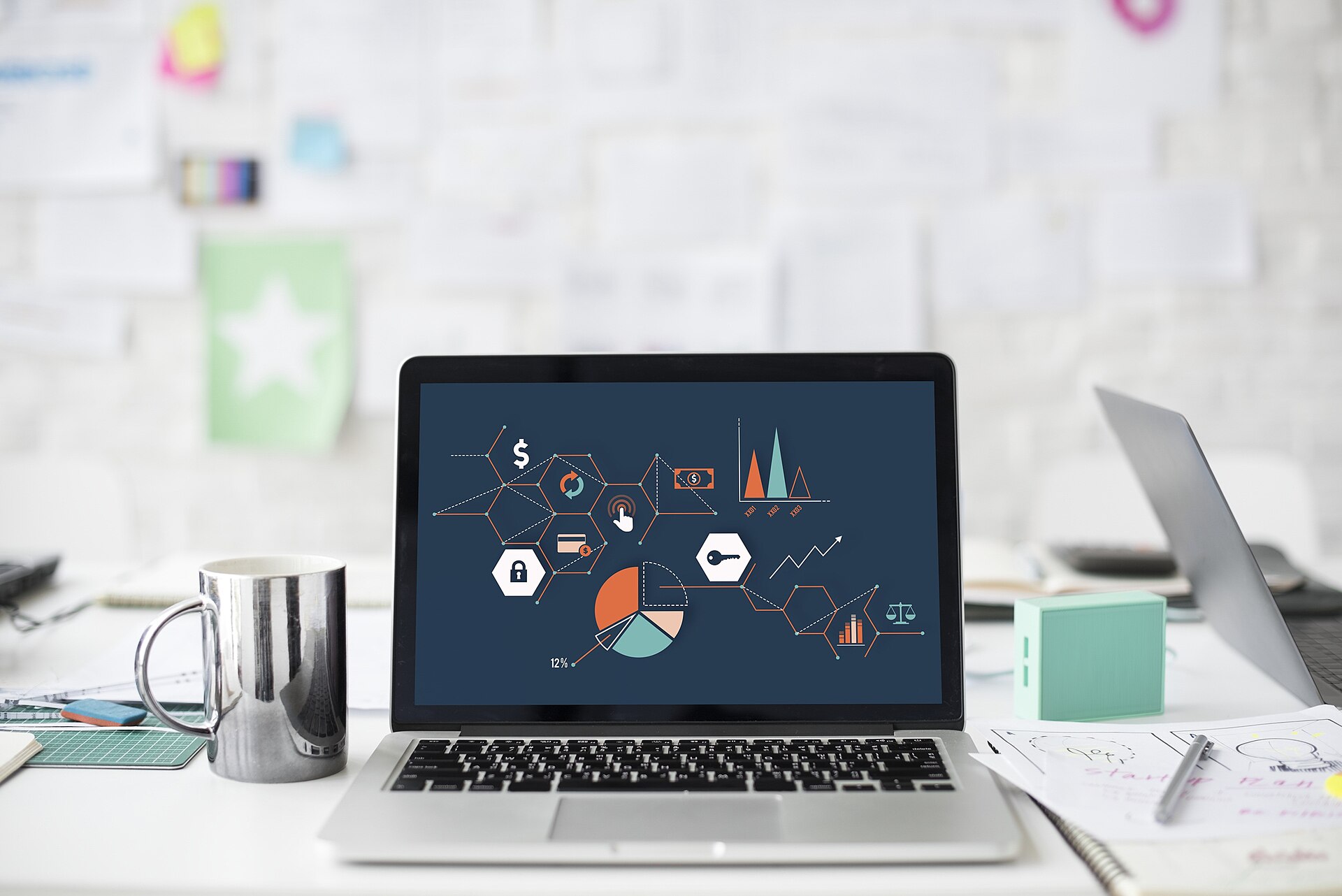 Laptop with many charts on screen on cluttered desk.jpg