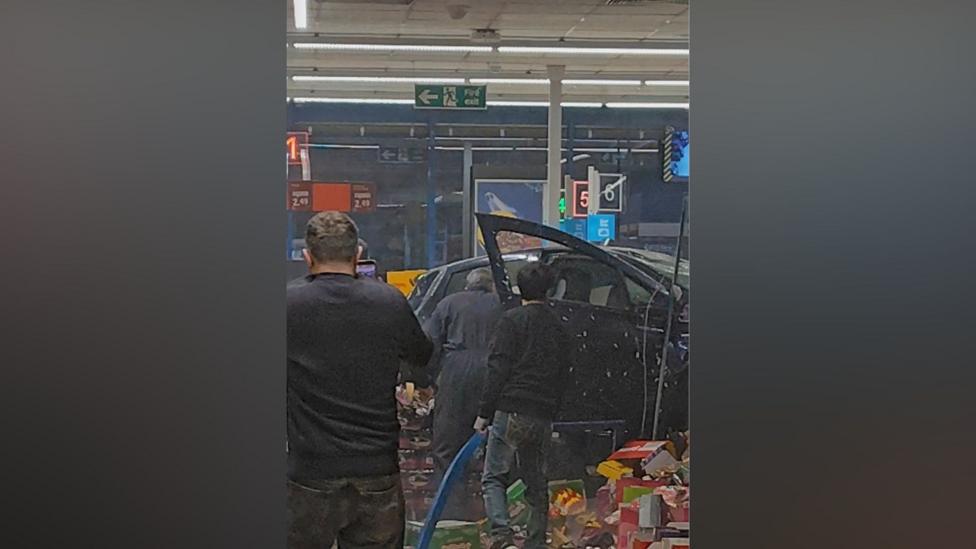 Image caption, The car ended up inside the shop as "terrified" eyewitnesses described a scene of "shock and confusion"
