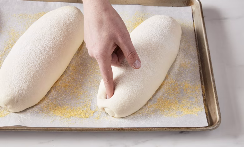 Finger poking a loaf of proofing bread dough