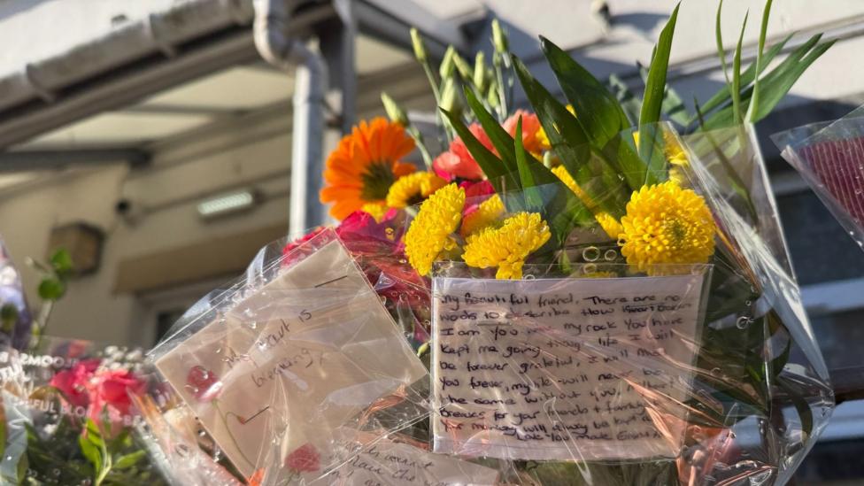 Image caption, Flowers left in tribute to Eleanor Barnfield who died earlier this week
